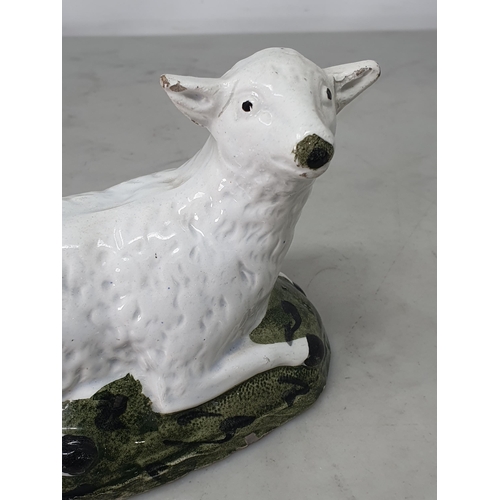 463 - An early 19th Century Staffordshire pearlware recumbent Ewe on mottled green shaped hollow base, A/F... 