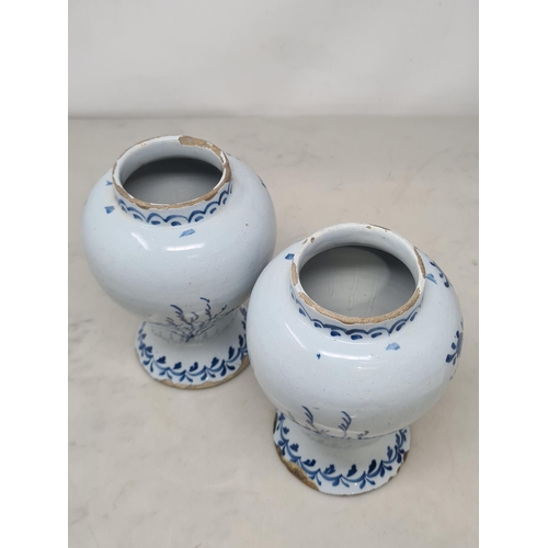 484 - A pair of Delft blue and white baluster Vases decorated with panels of flowers, 7in H