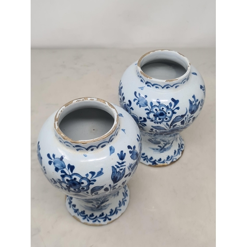 484 - A pair of Delft blue and white baluster Vases decorated with panels of flowers, 7in H