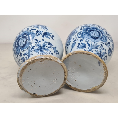 484 - A pair of Delft blue and white baluster Vases decorated with panels of flowers, 7in H