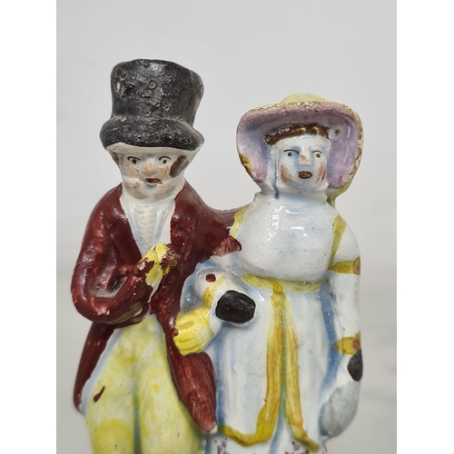 485 - A pearlware Staffordshire figure of the 'Dandies', the well-dressed couple in coats and hats, standi... 