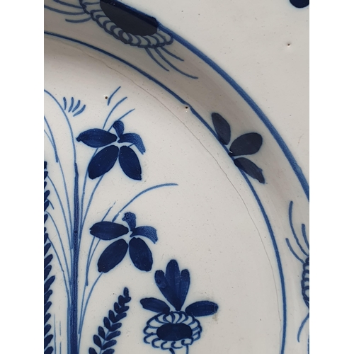 487 - An 18th Century blue and white Delft Charger with designs of sprays of flowers and repeat border des... 