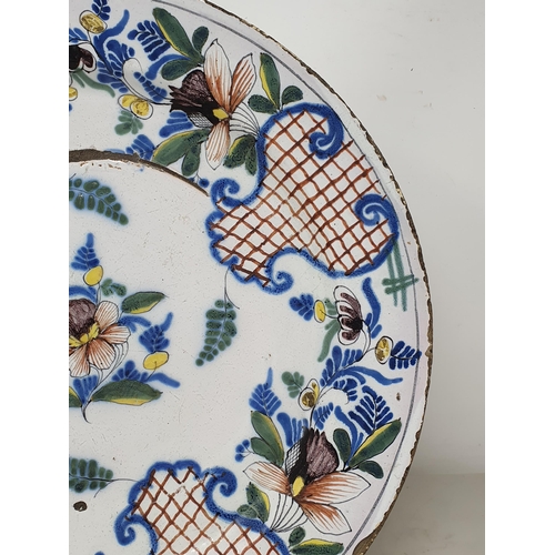 507 - A large antique Delft Charger in the Liverpool style, with floral and leafage border and central flo... 