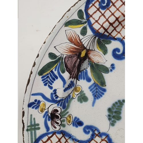 507 - A large antique Delft Charger in the Liverpool style, with floral and leafage border and central flo... 