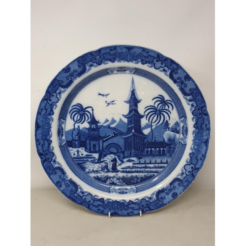 510 - A large blue and white 'Leeds Pottery' Charger with floral and scrolled rim, the centre decorated wi... 