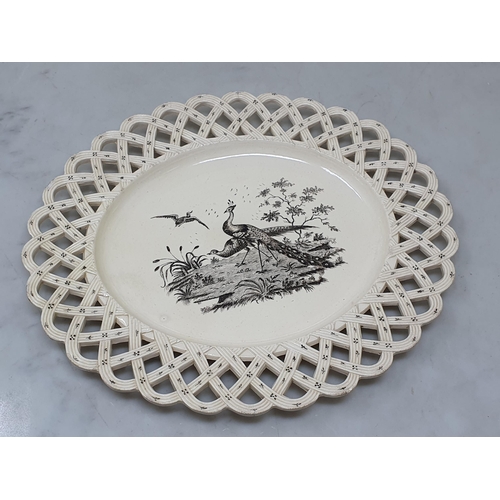 512 - A creamware Plate of oval form with pierced basket weave rim, the centre decorated with peafowl in l... 