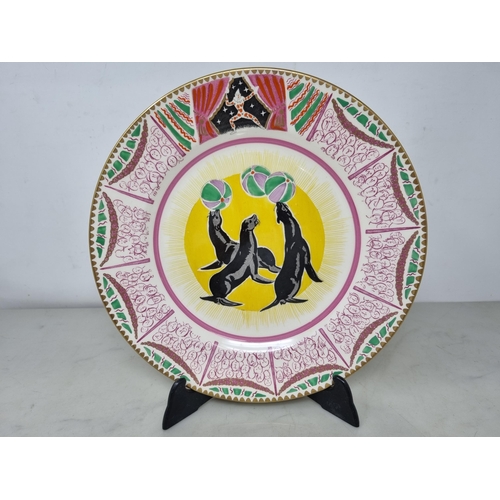 535 - Clarice Cliff Bizarre Plate, designed by Dame Laura Knight, decorated three seated Sea Lions, with c... 