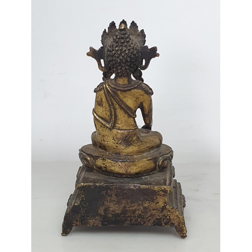 551 - An antique Nepalese gold washed bronze figure of a seated Buddha, 5 1/2in tall