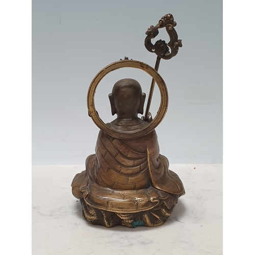 553 - A brass Figure of a seated Buddha with ceremonial staff 4 1/2in H