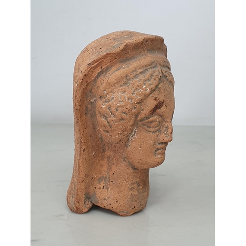 596 - A small Roman Terracotta Bust of a Lady wearing headdress, broken off at the lower neck, bearing old... 