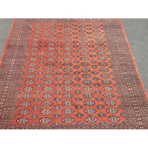 629 - A large Turkoman style Rug on red ground, with diamond and stylised flower design multi borders, the... 