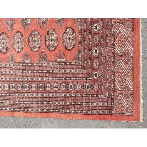 629 - A large Turkoman style Rug on red ground, with diamond and stylised flower design multi borders, the... 