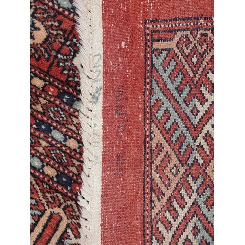 629 - A large Turkoman style Rug on red ground, with diamond and stylised flower design multi borders, the... 