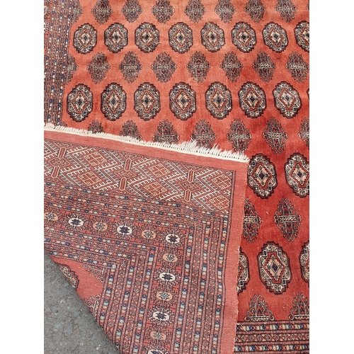 629 - A large Turkoman style Rug on red ground, with diamond and stylised flower design multi borders, the... 