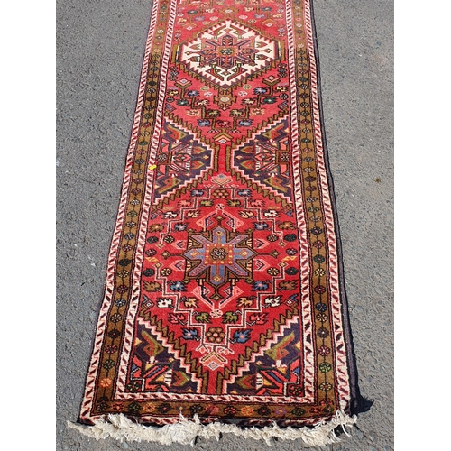 631 - A Persian/Iranian Runner, with floral multi borders, the centre with geometric design motifs and sty... 