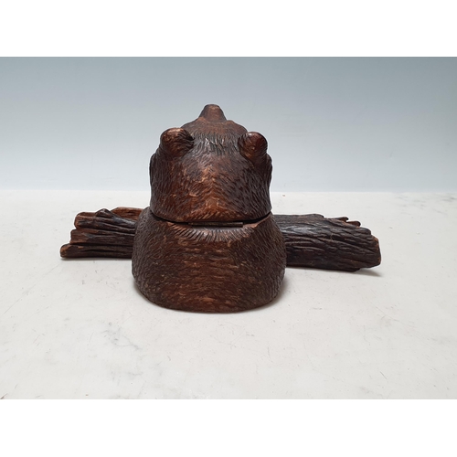 653 - A Black Forest carved Inkwell in the form of a bear holding a log 4 1/2in H