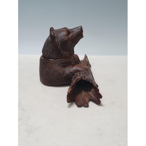 653 - A Black Forest carved Inkwell in the form of a bear holding a log 4 1/2in H