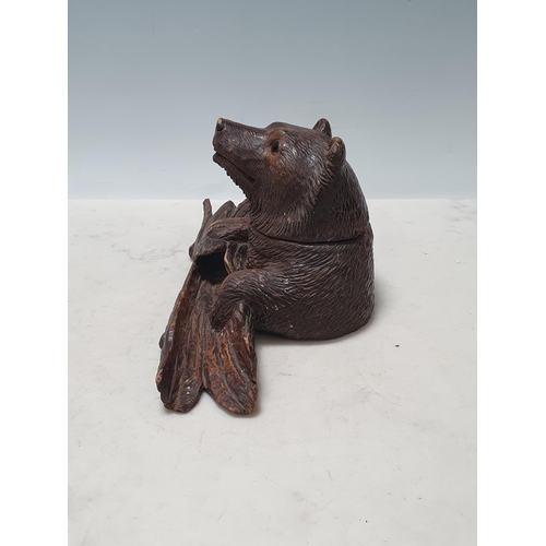 653 - A Black Forest carved Inkwell in the form of a bear holding a log 4 1/2in H