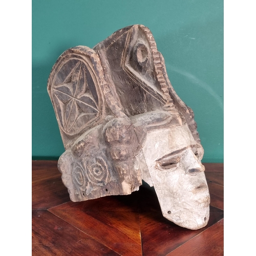 667 - A carved and painted helmet Mask with pierced eyes 1ft 3in H