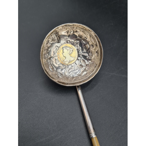 71 - A Georgian Toddy Ladle with floral embossed and coin inset circular bowl, spiral handle