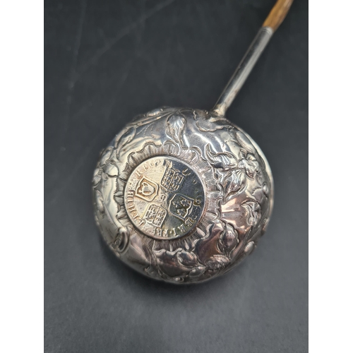 71 - A Georgian Toddy Ladle with floral embossed and coin inset circular bowl, spiral handle