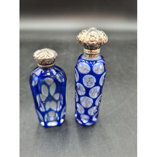 75 - Two blue overlaid glass Scent Bottles with embossed silver lids, small chips