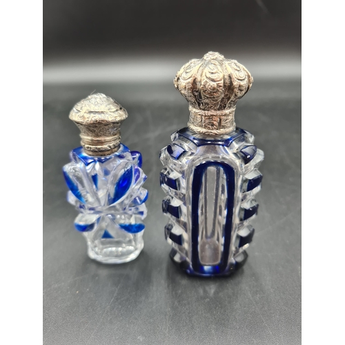 76 - Two blue overlaid glass Scent Bottles with embossed silver lids, small chips