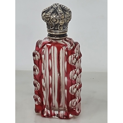 80 - A red cut glass Scent Bottle of horn shape with scroll embossed lid, and a red overlaid glass Scent ... 