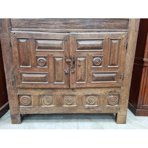 343 - An 18th Century oak Continental Cupboard having two pairs of cupboard doors with multiple panels abo... 