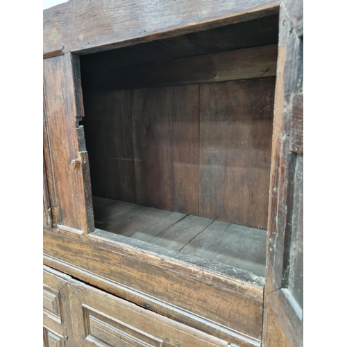 343 - An 18th Century oak Continental Cupboard having two pairs of cupboard doors with multiple panels abo... 