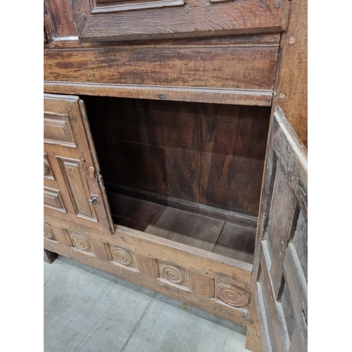 343 - An 18th Century oak Continental Cupboard having two pairs of cupboard doors with multiple panels abo... 