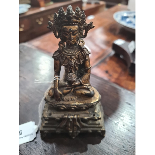 551 - An antique Nepalese gold washed bronze figure of a seated Buddha, 5 1/2in tall