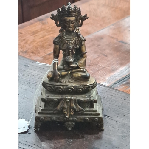 551 - An antique Nepalese gold washed bronze figure of a seated Buddha, 5 1/2in tall