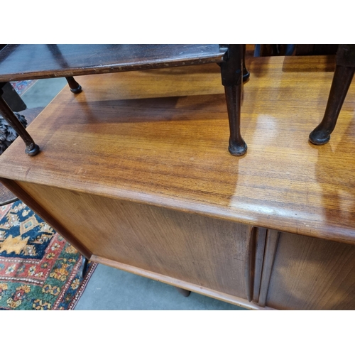 349 - A mid-century Danish teak Sideboard fitted three cupboard doors and four drawers on turned supports ... 