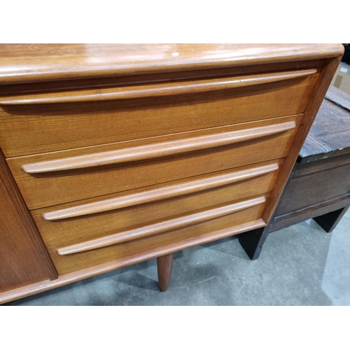 349 - A mid-century Danish teak Sideboard fitted three cupboard doors and four drawers on turned supports ... 