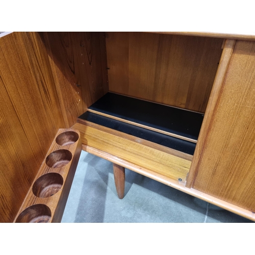 349 - A mid-century Danish teak Sideboard fitted three cupboard doors and four drawers on turned supports ... 