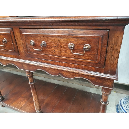 450 - A large oak Dresser and Rack fitted four moulded frieze drawers above a shaped frieze on baluster tu... 