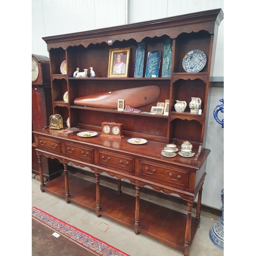 450 - A large oak Dresser and Rack fitted four moulded frieze drawers above a shaped frieze on baluster tu... 