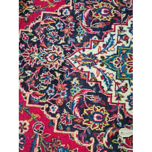 11 - A modern bordered Persian Carpet with large oval floral medallion on a red ground, palmette main bor... 