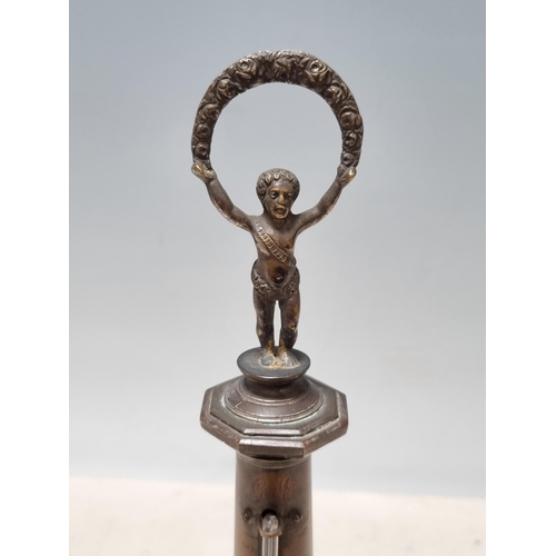 643 - An antique brass Thermometer in the form of a lighthouse with figural child finial raised on circula... 