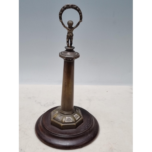 643 - An antique brass Thermometer in the form of a lighthouse with figural child finial raised on circula... 