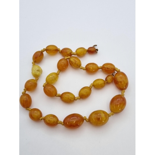 188 - An Amber type bead Necklace, approx 40gms, two damaged beads (hot needle test suggests amber) on dam... 