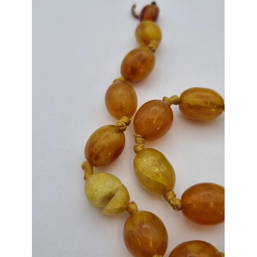 188 - An Amber type bead Necklace, approx 40gms, two damaged beads (hot needle test suggests amber) on dam... 