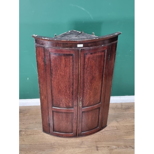 13 - An antique bow front Hanging Corner Cupboard with pair of panelled doors, A/F (Locked), 3ft 10