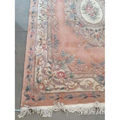 458 - A Chinese peach ground Carpet with floral oval central panel within cream borders 9ft 4in L x 6ft W ... 