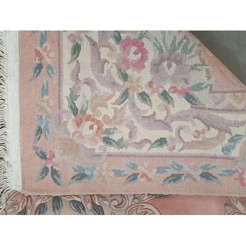 458 - A Chinese peach ground Carpet with floral oval central panel within cream borders 9ft 4in L x 6ft W ... 