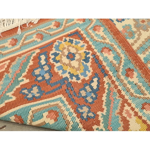 536 - A red ground woolen Rug with pale blue central lozenge with floral design within tramline borders 9f... 