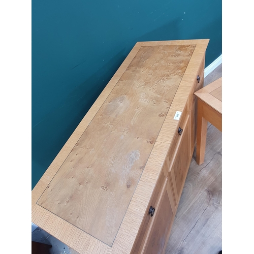 605 - A modern oak veneered Sideboard fitted three frieze drawers above three cupboard doors marked 'Wade'... 