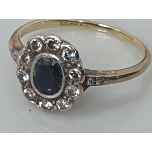 675 - A yellow metal Dress Ring set with central oval sapphire surrounded by ten diamonds, further diamond... 