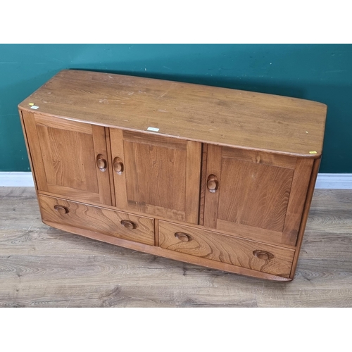 7 - An Ercol blonde elm Sideboard fitted three cupboard doors above two drawers raised on casters 4ft 3i... 